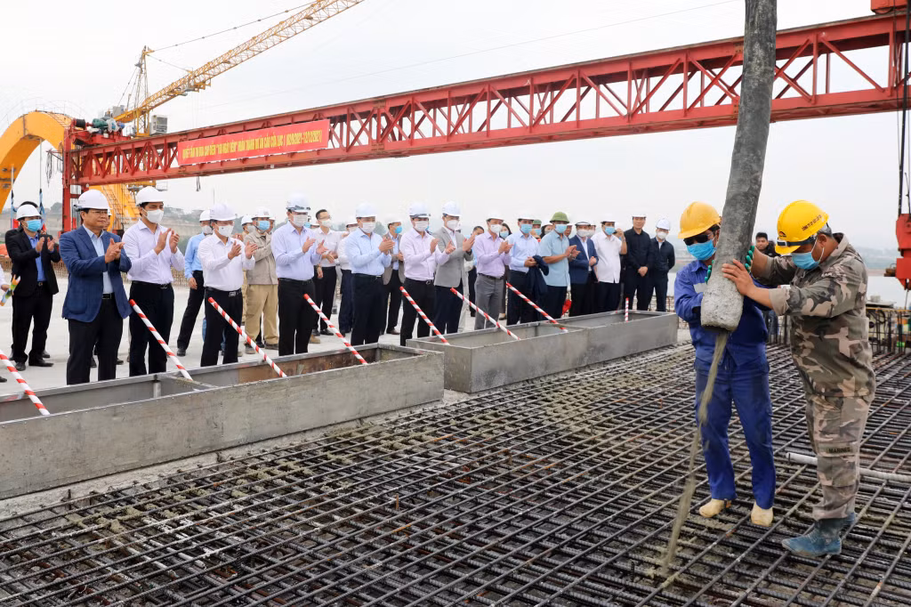 Tháng 9/2021, công trình thi công xong dầm chính của cầu chính; tháng 10/2021 hoàn thiện bê tông nhồi vòm thép, lắp đặt cáp treo và hợp long ngày 2/11/2021.