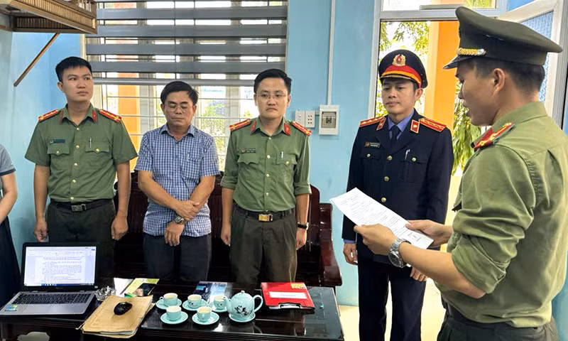 Cơ quan công an tống đạt quyết định khởi tố bị can và bắt tạm giam đối với Nguyễn Viết Sơn (Trưởng BQL các công trình công cộng huyện Lệ Thủy). Ảnh: Công an Quảng Bình