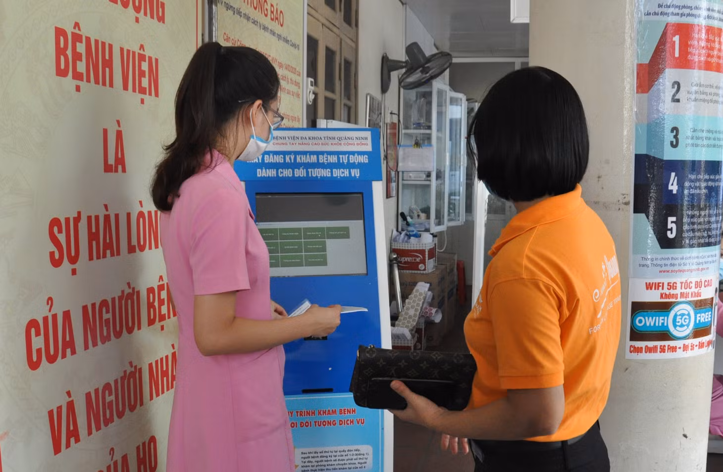 Nhân viên Bệnh viện Đa khoa tỉnh hướng dẫn người dân lấy số tự động khi đến khám, chữa bệnh tại Bệnh viện.