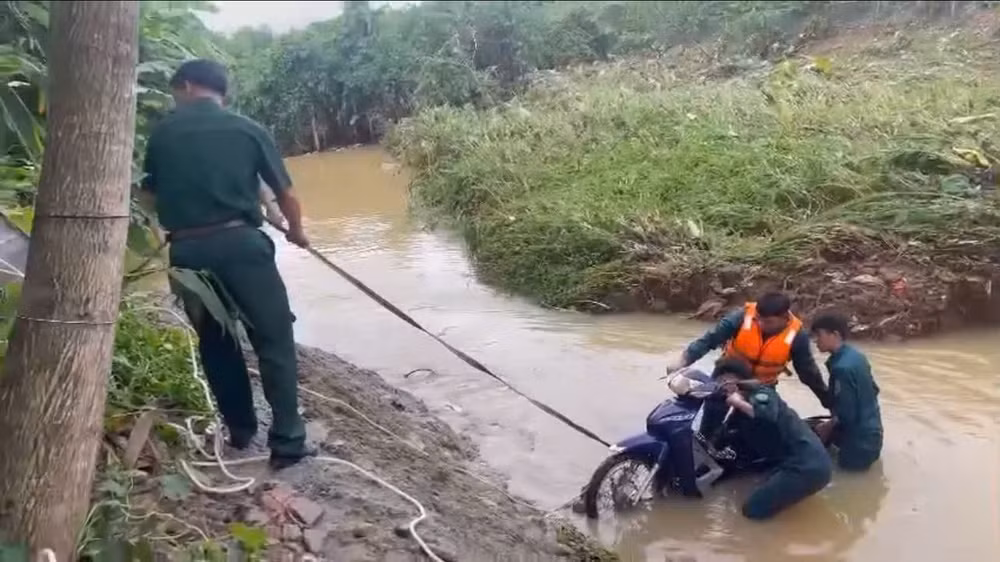 Lực lượng chức năng trục vớt xe máy bị nước cuốn trôi.