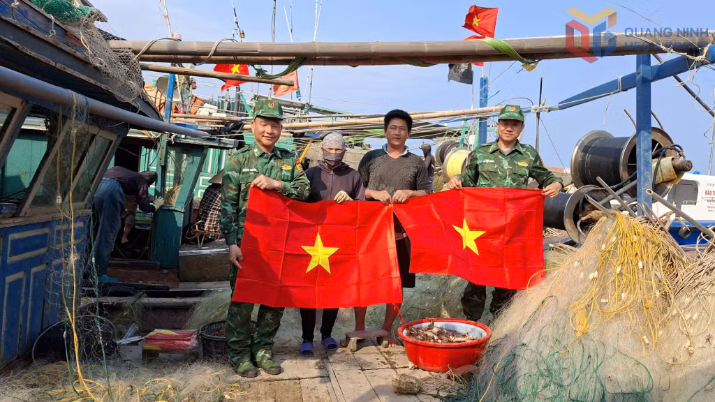 Đồn BP Đảo Trần tặng cờ Tổ quốc cho ngư dân.