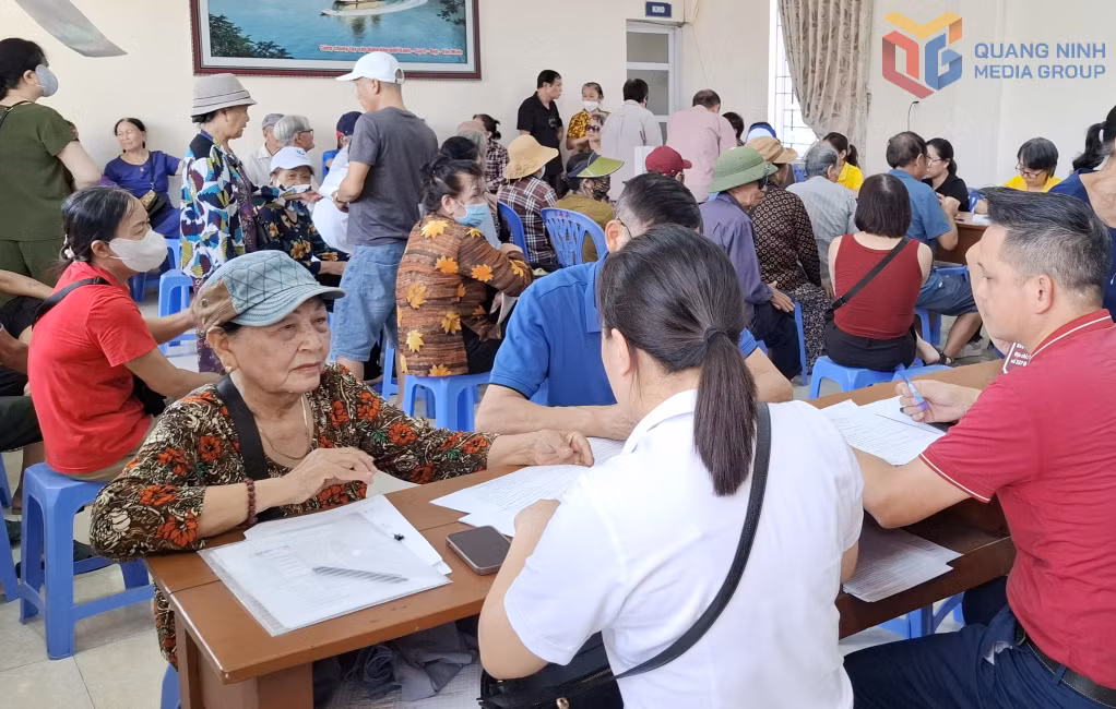 Bà Đặng Thị Tươi, ở Khu 7, phường Cao Xanh được cán bộ BHXH tỉnh hướng dẫn chi trả lương hưu thông qua tài khoản ATM.