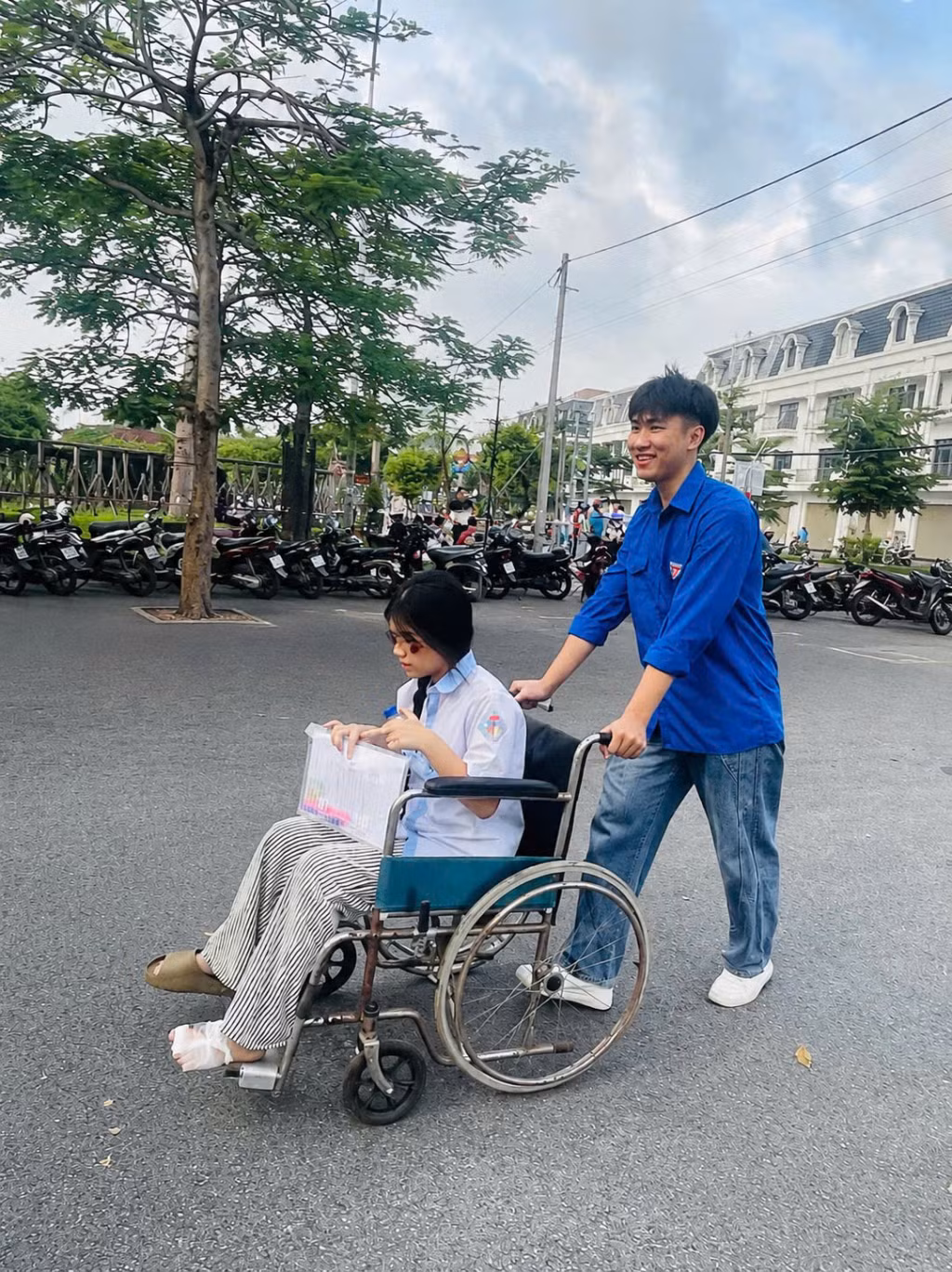 Thí sinh dự thi tại điểm thi Trường THPT Quảng Hà bị đau chân không thể tự đi lại, được lực lượng thanh niên tình nguyện giúp đỡ. Ảnh: Lưu Linh