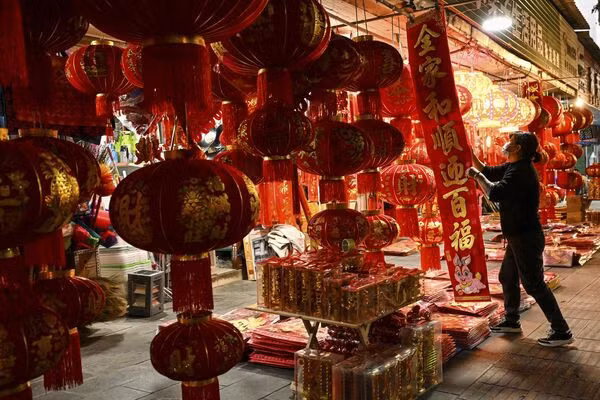 Người bán hàng xếp đèn lồng và các đồ trang trí khác dọc con phố ở thành phố Ruili, tỉnh Vân Nam, Trung Quốc. Ảnh: AFP