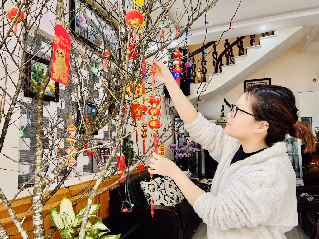 Người dân phấn khởi trang trí cành đào chuẩn bị đón Xuân sang.