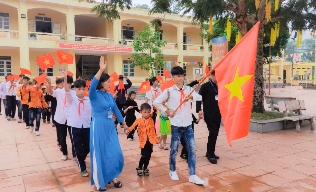Học sinh lớp 1, Trường Tiểu học và THCS Lương Mông được cô giáo dẫn đến trường trong ngày khai giảng.
