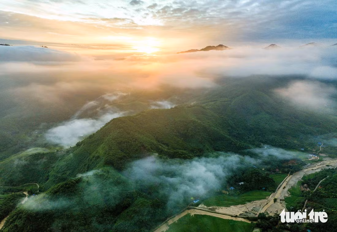 Bình minh tại Làng Nủ với những tia nắng vàng và mây luồn sà trên mặt núi, phía dưới là suối Vằng Cuồng sau cơn lũ quét - Ảnh: NGUYỄN KHÁNH