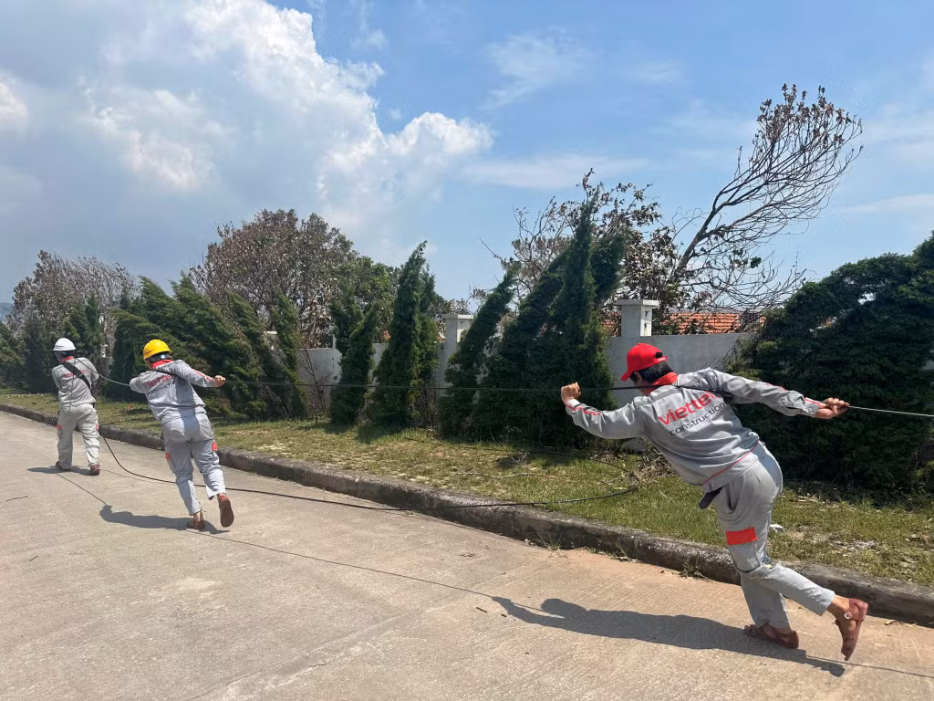 Nhân viên Viettel Quảng Ninh cùng lực lượng hỗ trợ kéo dây cáp từ trạm chính đến các trạm nhánh tại phường Tuần Châu (TP Hạ Long).