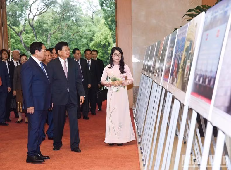 Thủ tướng Phạm Minh Chính giới thiệu với Tổng Bí thư, Chủ tịch nước Lào Thongloun Sisoulith những bức ảnh nói về quan hệ hữu nghị đặc biệt hai nước. (Ảnh: TRẦN HẢI)