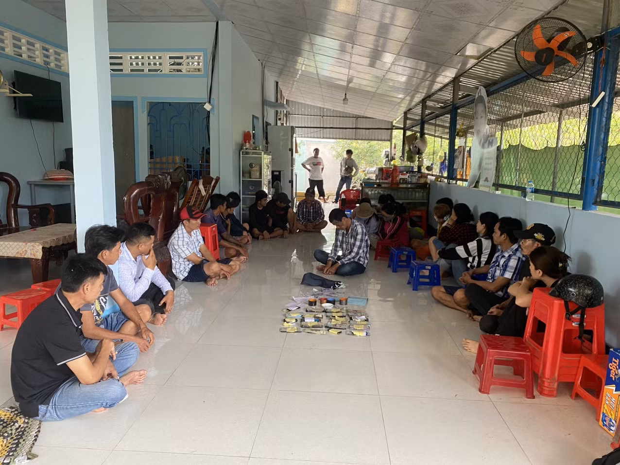 Nhóm đối tượng đánh bạc cùng tang vật bị bắt giữ tại hiện trường. Ảnh: Công an cung cấp.