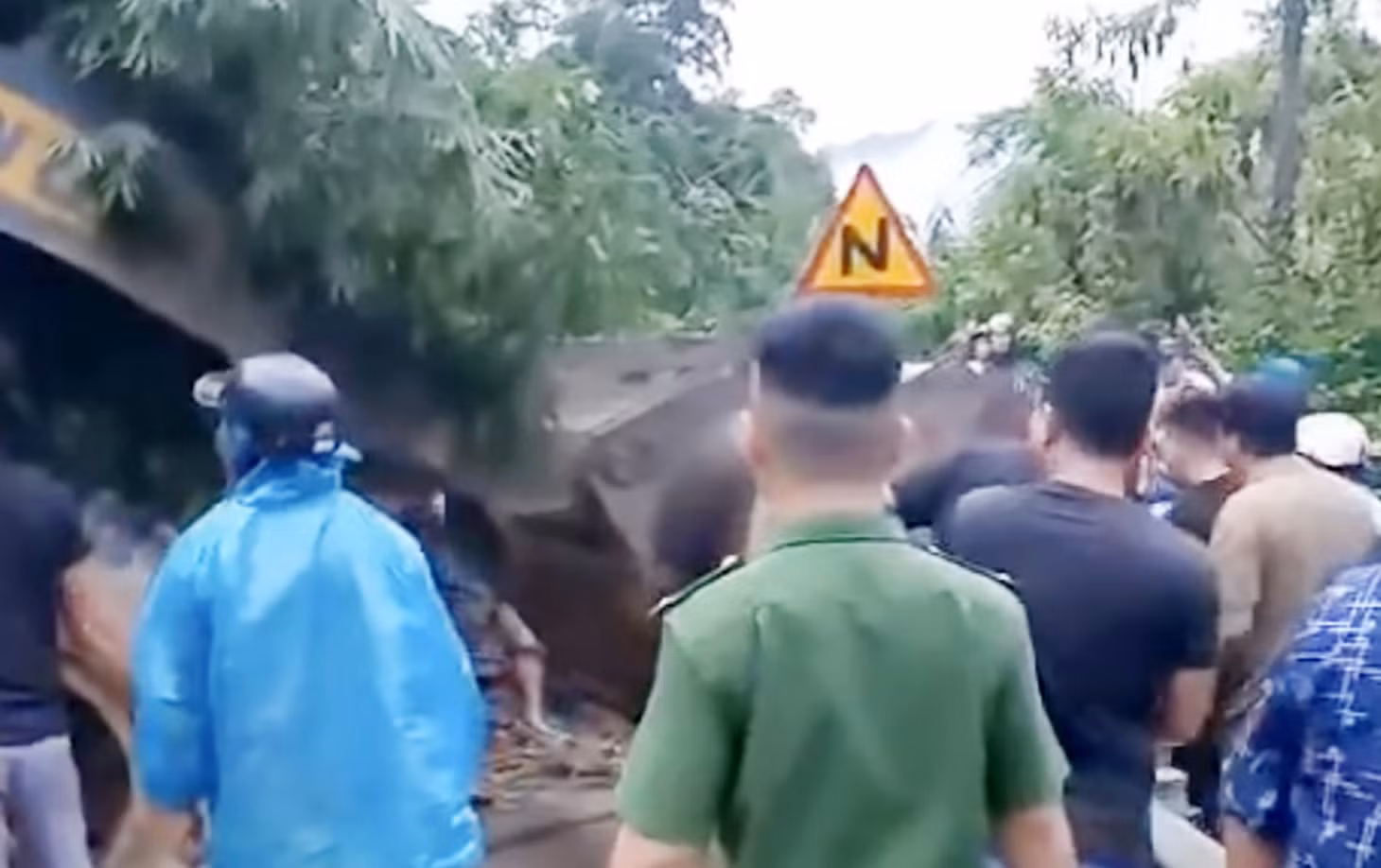 Máy móc và nhiều người chung tay giải cứu 2 cô giáo đị đất đá vùi. Ảnh cắt từ video clip
