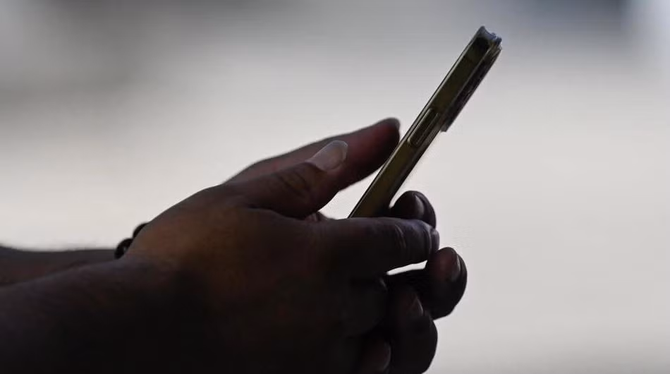 Một người dùng điện thoại iPhone. Ảnh: AFP