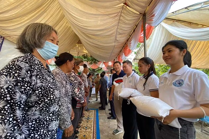 Cán bộ Đại sứ quán Việt Nam và Bệnh viện Chợ rẫy Phnom Penh trao quà cho bà con. (Ảnh: Sơn Xinh)