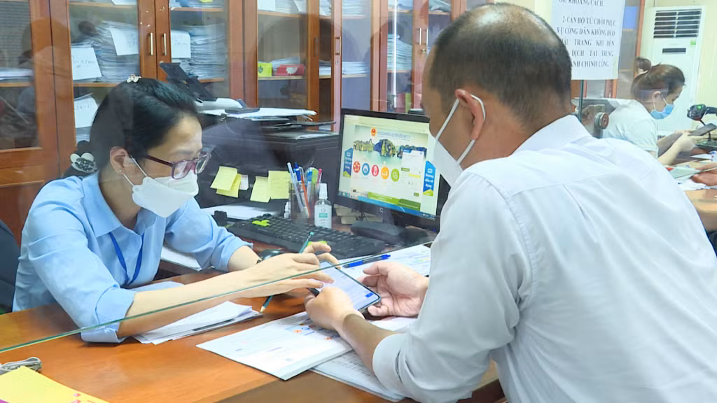 Cán bộ Trung tâm Hành chính công TP Hạ Long hướng dẫn cho người dân nộp thủ tục hành chính qua dịch vụ công.