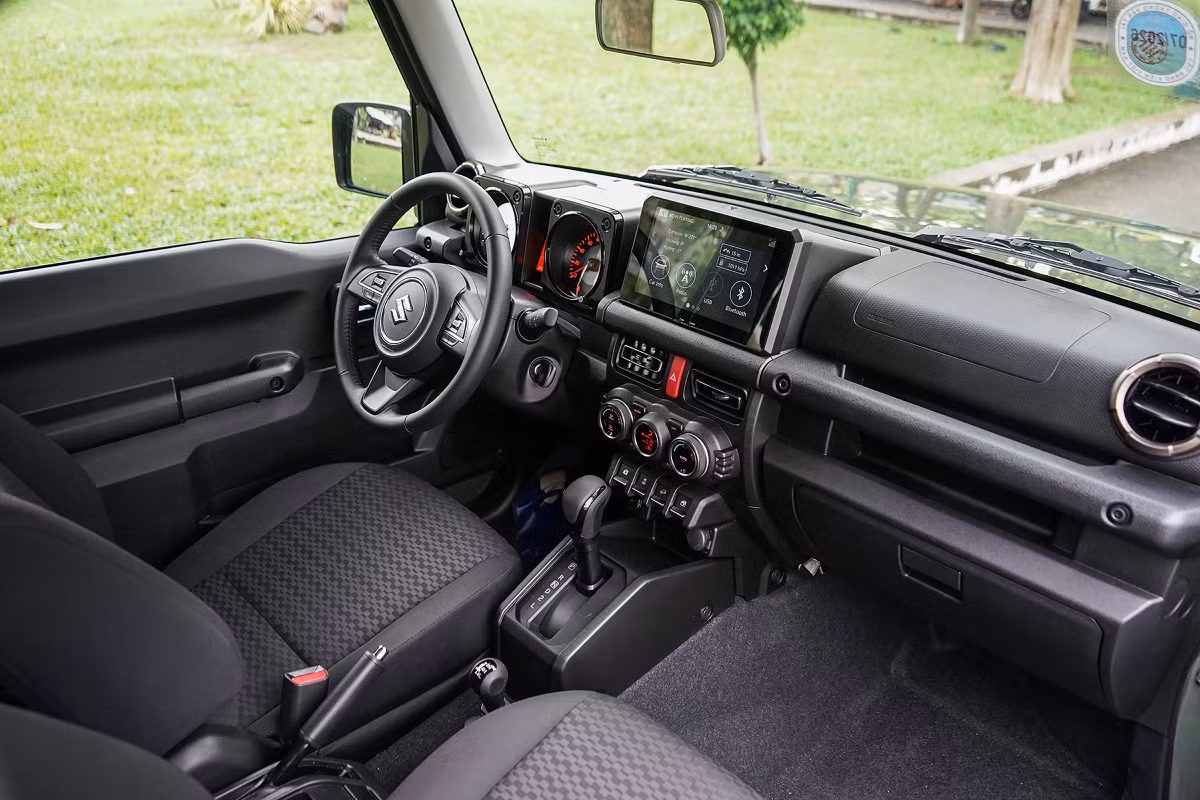 Khoang lái Suzuki Jimny đơn giản với tất cả các chi tiết đều bằng nhựa cứng. Các vị trí ngồi đều có thanh giằng để cầm, nắm khi đi off-road.