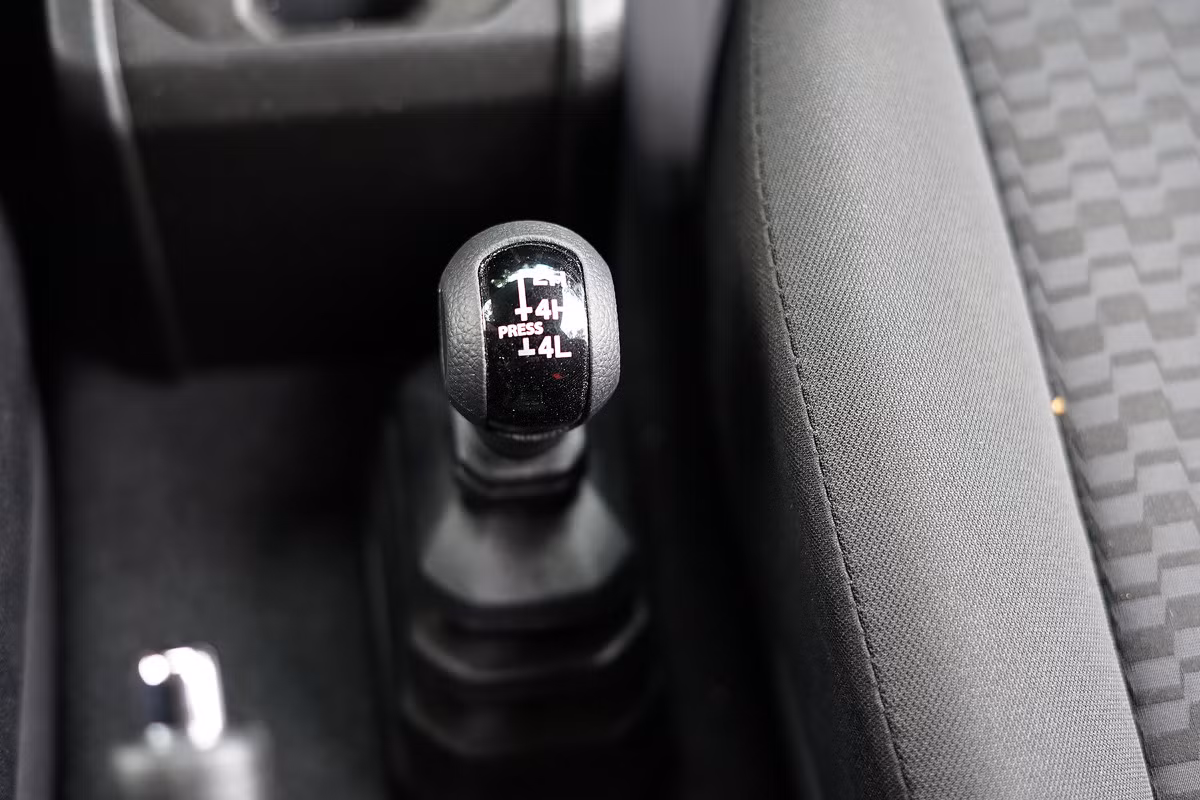 Jimny dẫn động hai cầu. Việc chuyển đổi giữa các chế độ như một cầu nhanh, hai cầu nhanh, hai cầu chậm được thực hiện bằng tay thông qua cần phụ cạnh cần số chính.