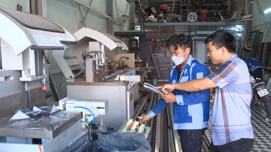 Anh Vũ Văn Lập, Giám đốc Công ty CP Sản xuất cơ khí và Thương mại Hùng Cường (bên phải) trao đổi, hướng dẫn công nhân trong quá trình sản xuất. Ảnh: Việt Hưng.