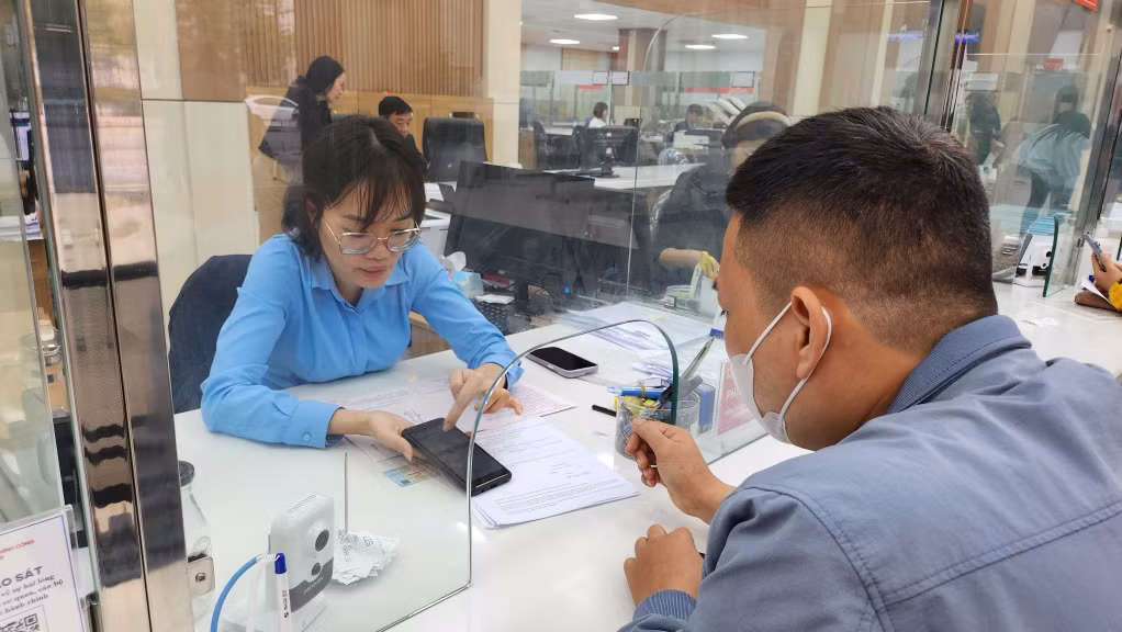 Cán bộ Trung tâm Hành chính công TP Hạ Long hướng dẫn người dân thực hiện TTHC qua dịch vụ công trực tuyến.