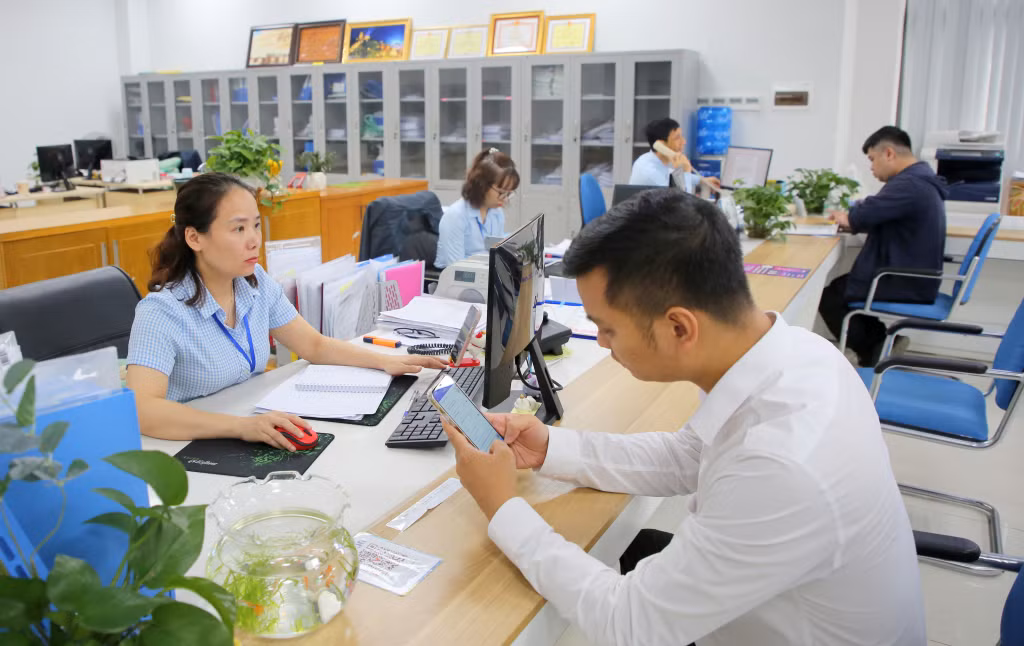 Cán bộ Trung tâm Phục vụ hành chính công tỉnh hướng dẫn, hỗ trợ người dân, doanh nghiệp giải quyết TTHC. Ảnh: Song Hà