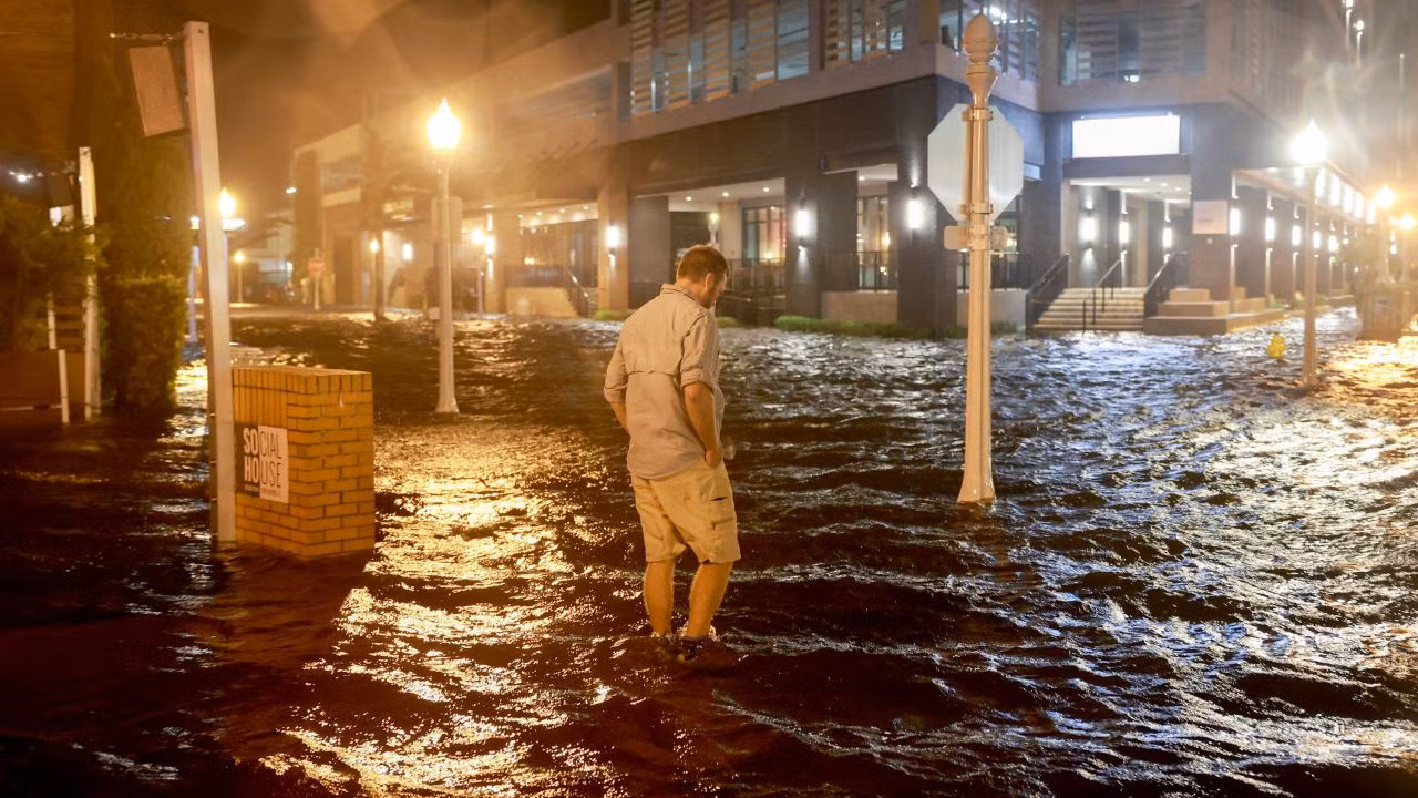 Người đàn ông đi bộ qua một con phố ngập lụt ở Fort Myers, Florida. Ảnh: Getty Images