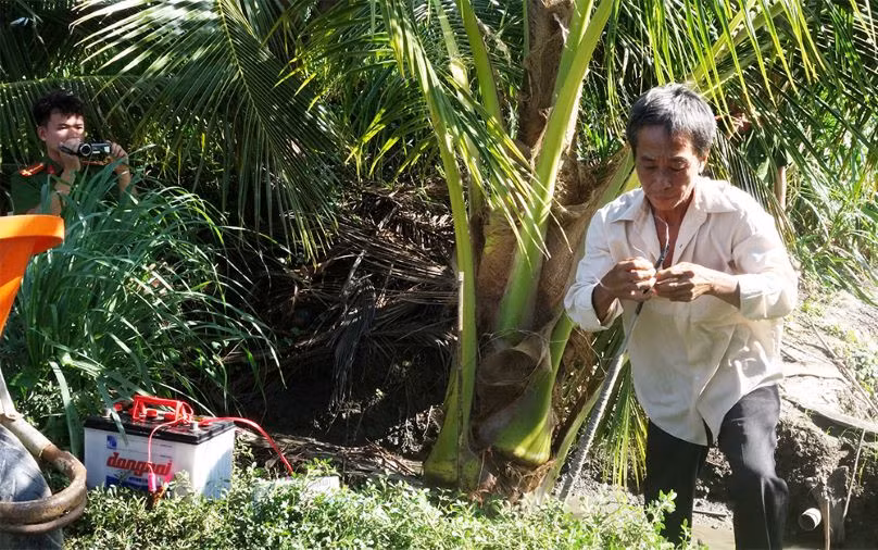 Đối tượng Lê Thanh Tuyền thực hiện lại hành vi dùng điện bẫy chuột làm chết người. Ảnh: Vũ Tiến