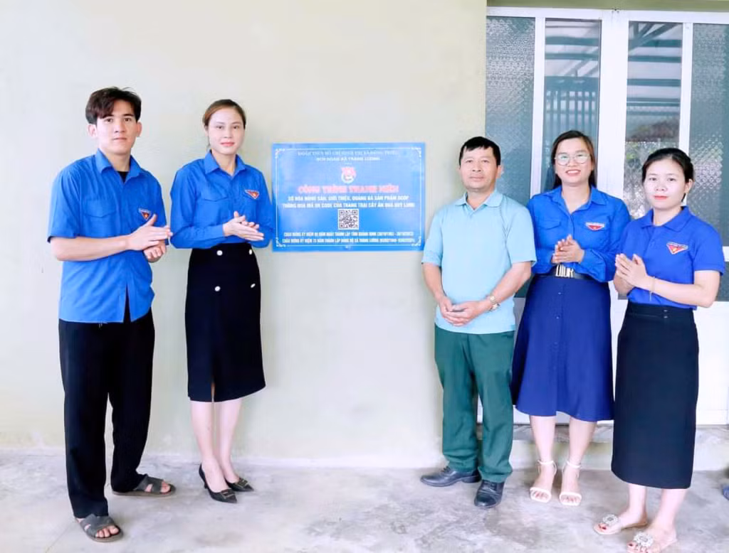 Chị Trần Thị Ánh Nhung cùng ĐVTN xã Tràng Lương trao tặng công trình thanh niên "Gắn mã QR code số hóa nông sản, quảng bá, giới thiệu sản phẩm ổi OCOP của địa phương tại trang trại hoa quả Quý Long". Ảnh: Nhân vật cung cấp