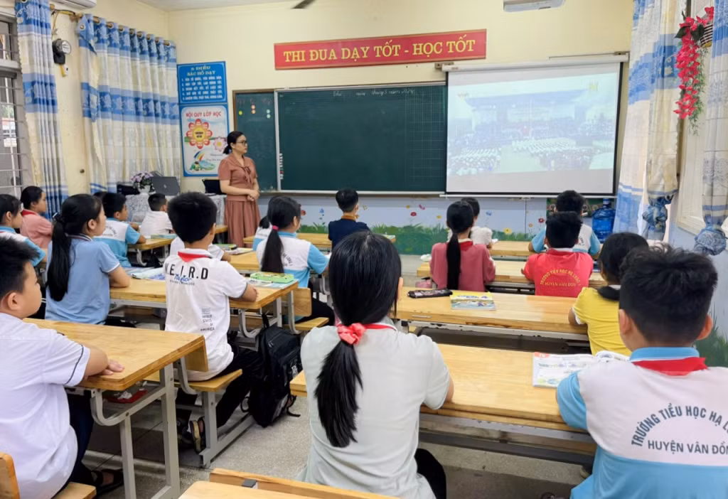 Cô và trò Trường Tiểu học Hạ Long 1 (huyện Vân Đồn) xem trực tiếp Lễ kỷ niệm 70 năm Chiến thắng Điện Biên Phủ qua màn hình tại phòng học.