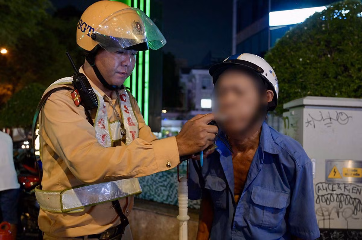 Lực lượng chức năng thực hiện đo nồng độ cồn người điều khiển phương tiện tham gia giao thông, đêm 24.5. Ảnh: Như Quỳnh