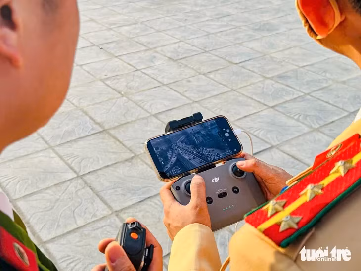 Khi phát hiện ùn tắc hoặc va chạm giao thông, lực lượng chức năng dùng bộ đàm thông báo cho tổ công tác phân luồng từ xa - Ảnh: HỒNG QUANG