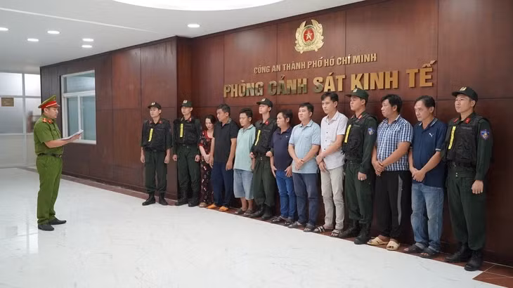 Cơ quan điều tra tống đạt lệnh bắt các bị can trong đường dây sản xuất, buôn bán xăng giả - Ảnh: C.A.