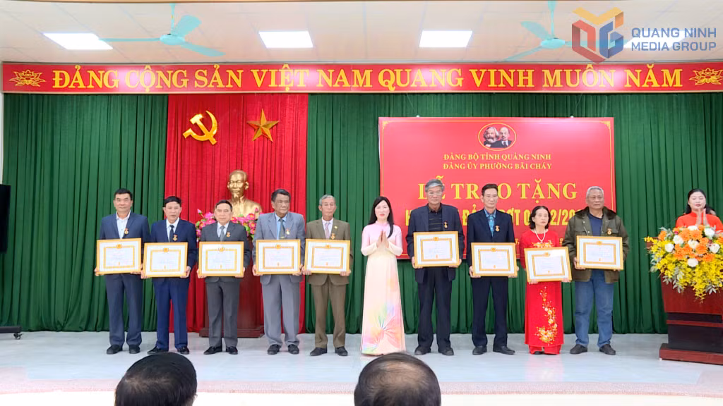 Đồng chí Đinh Thị Nhung, Phó Bí thư Thường trực Đảng ủy phường Bãi Cháy trao Huy hiệu Đảng cho các đảng viên.