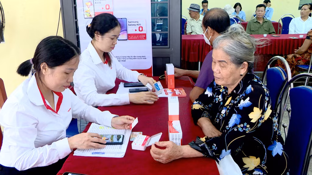 Nhân viên nhà mạng Viettel hỗ trợ người dân khu 10, phường Quang Trung (TP Uông Bí) chuyển đổi sim và máy 2G lên 4G.