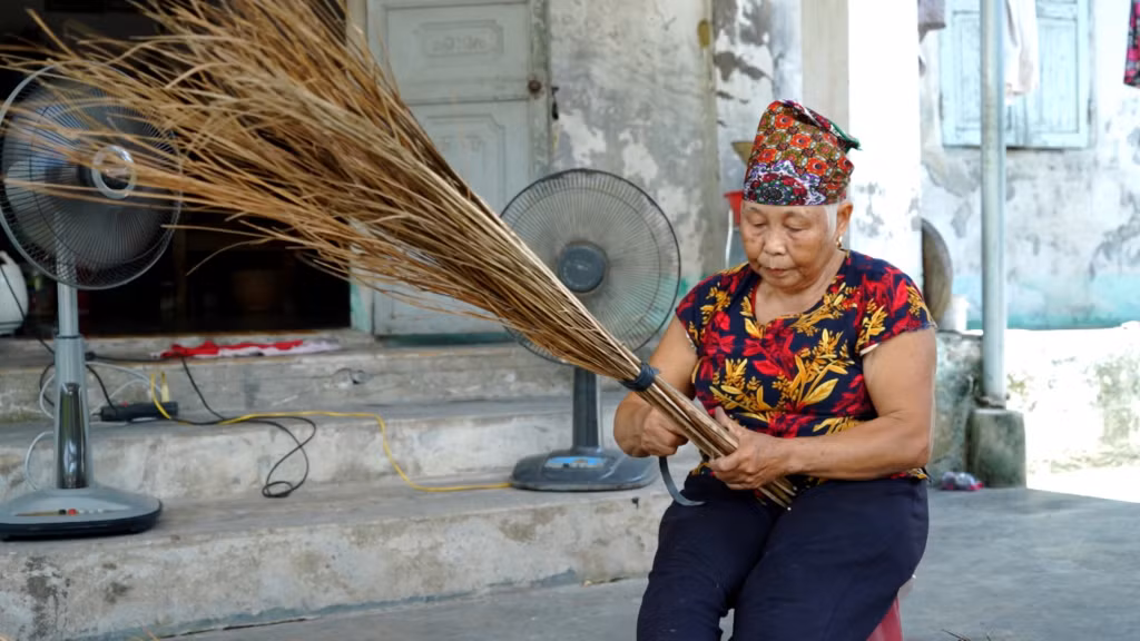 Bà Cao Thị Liên đang hoàn thiện các công đoạn làm chiếc chổi dừa.