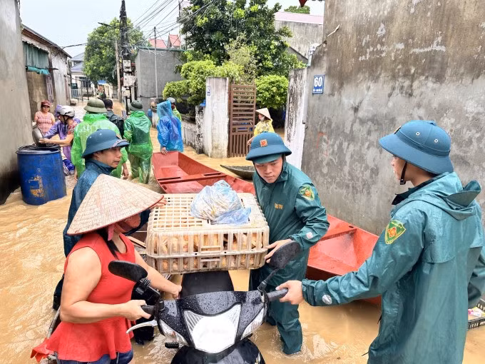 Dân quân tự vệ giúp người dân ngoại thành Hà Nội di tản đồ đạc trong đợt lũ cuối tháng 7 đầu tháng 8/2024. Ảnh: Gia Chính