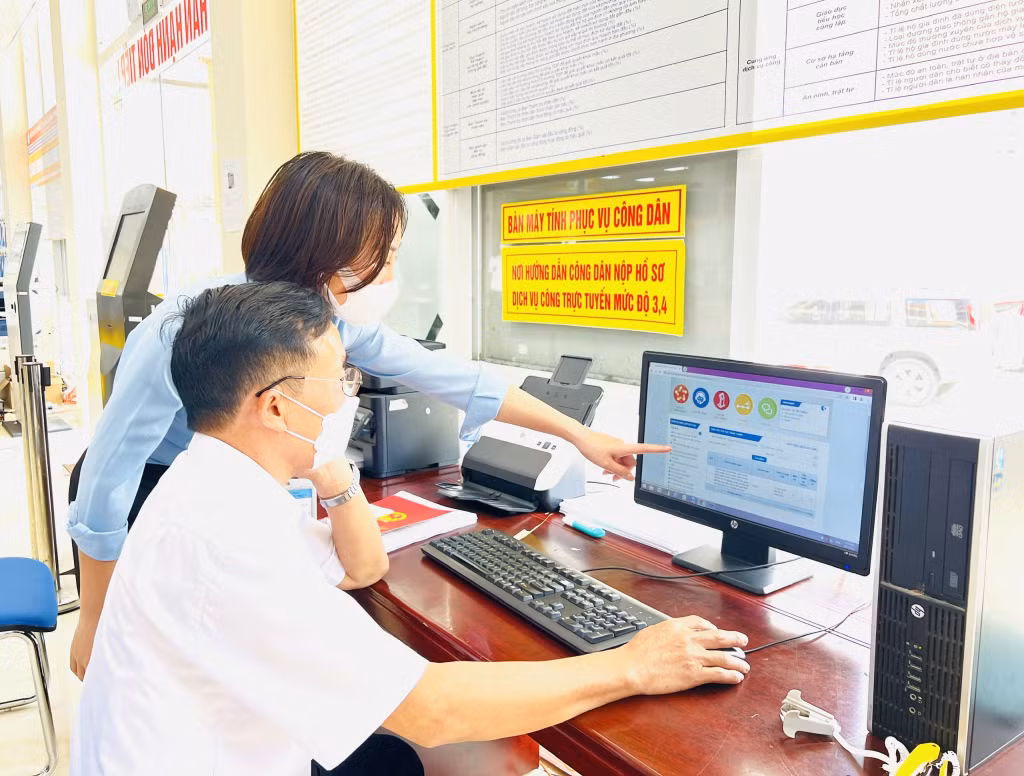 Cán bộ Trung tâm Hành chính công TX Đông Triều hướng dẫn người dân kê khai TTHC. Ảnh: Thanh Hằng
