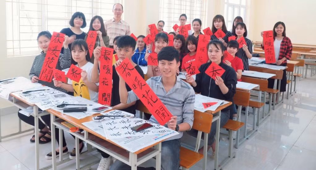 Chuyên gia tiếng Trung Hsieh Tso Yuan (đứng phía sau) hướng dẫn sinh viên ngành Ngôn ngữ Trung Quốc viết thư pháp.