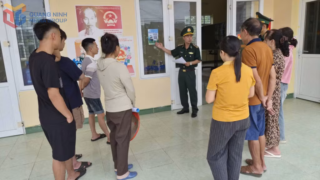 Cán bộ Đồn BP Cô Tô hướng dẫn người dân trên địa bàn cách quét mã QR tố giác tội phạm.
