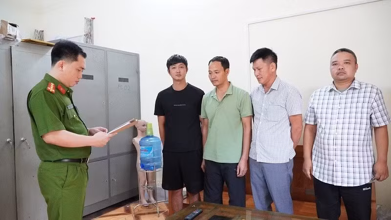 Cán bộ cơ quan điều tra Công an tỉnh Điện Biên đọc quyết định khởi tố bị can đối với 4 đối tượng. (Ảnh: CÔNG AN ĐIỆN BIÊN)
