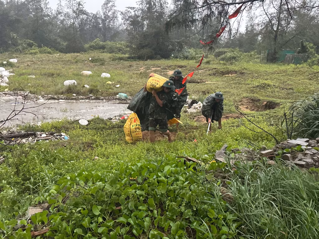 Lực lượng vũ trang trên địa bàn xã Vĩnh Thực ấy cát để giúp nhân dân gia cố những mái nhà yếu trong bão. Ảnh: Hữu Việt