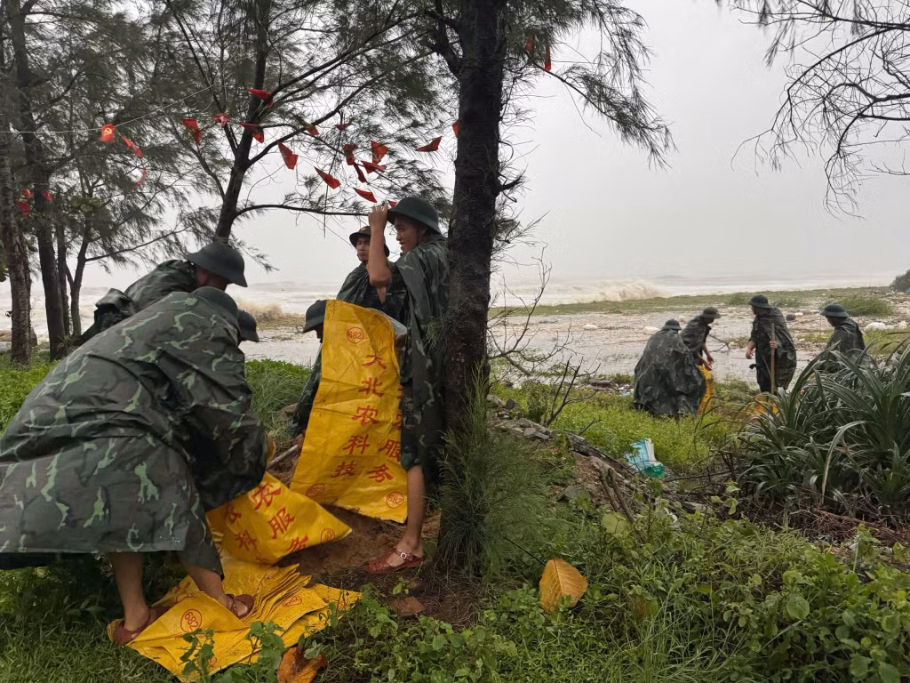 Lực lượng vũ trang trên địa bàn xã lấy cát để giúp nhân dân gia cố những mái nhà yếu trong bão.