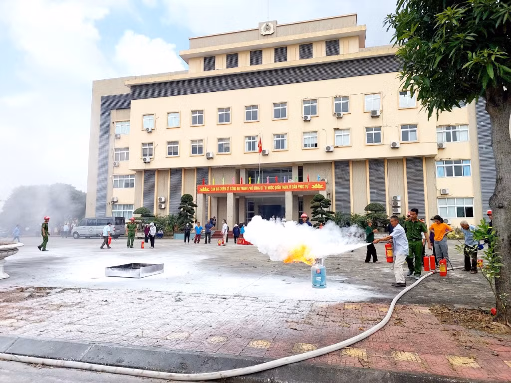 Công an TP Uông Bí hướng dẫn thao tác sử dụng bình chữa cháy cho các hộ dân.