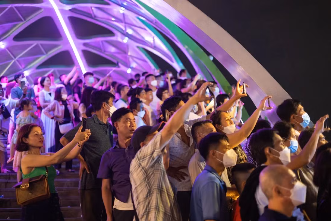 Mọi người dùng smartphone chụp ảnh tại một buổi trình diễn ánh sáng tại Phú Quốc. (Ảnh: Bloomberg).