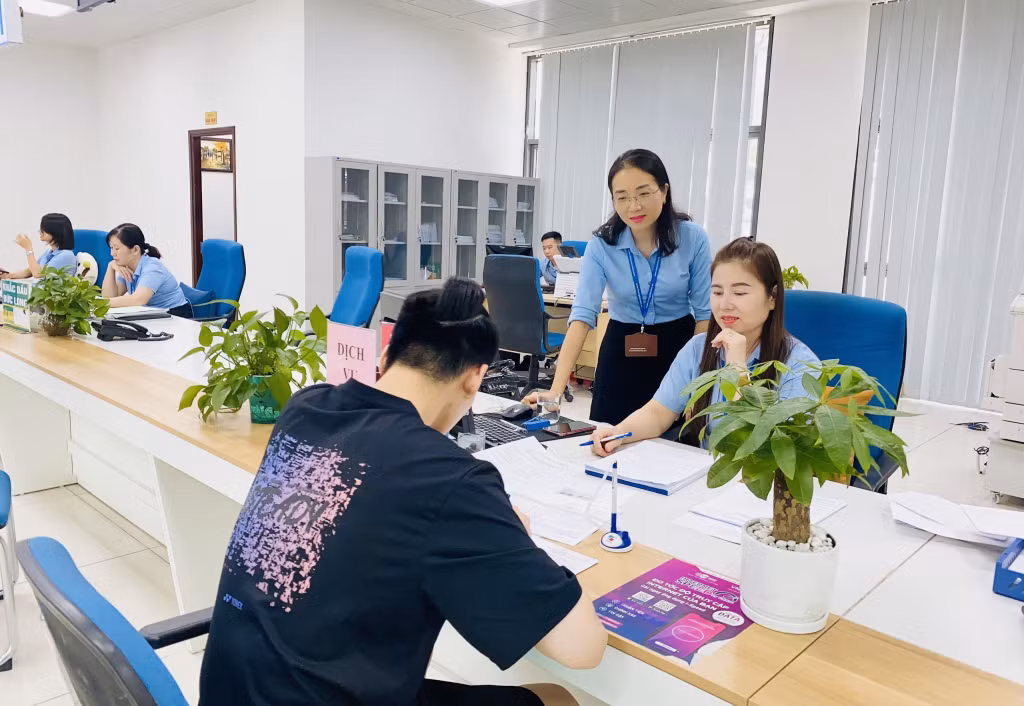 Chị Hương (người đứng) cùng với cán bộ Trung tâm Phục vụ hành chính công tỉnh hỗ trợ người dân giải quyết TTHC.