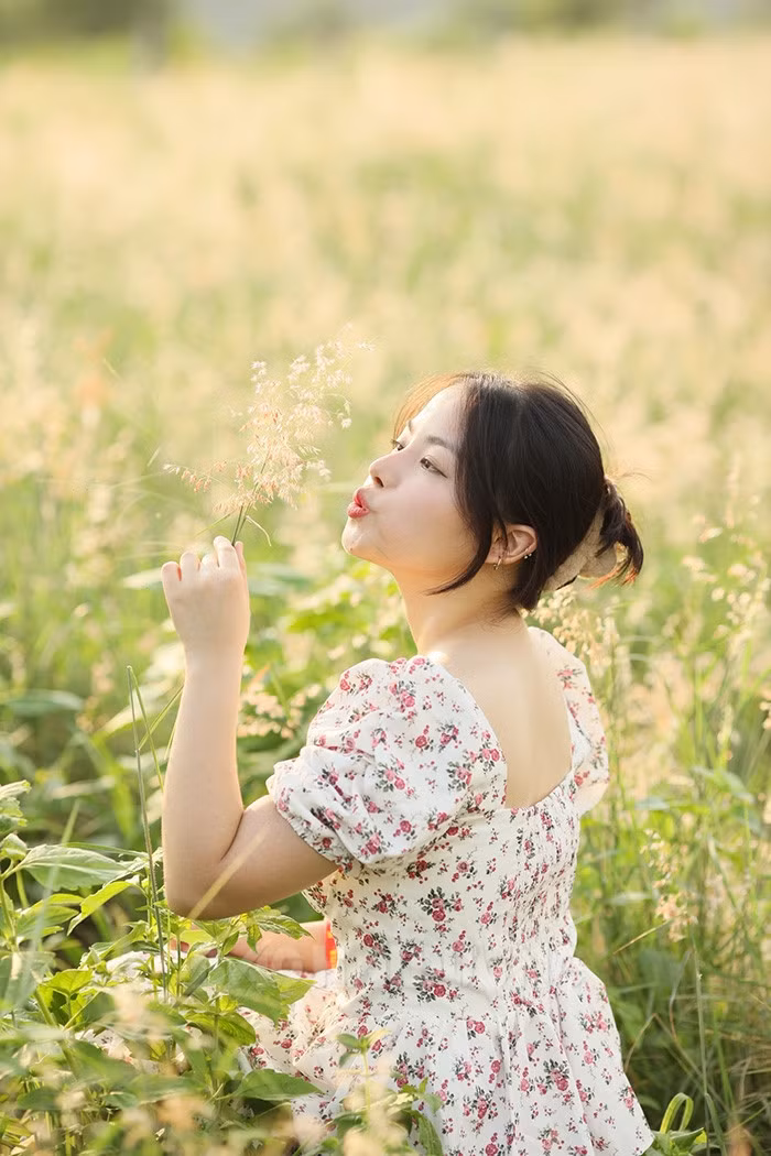 Hình ảnh người thiếu nữ vui đùa cùng những bông hoa cỏ bung sắc hồng dưới nắng chiều tạo nên khung cảnh rất lãng mạn, đẹp đến nao lòng