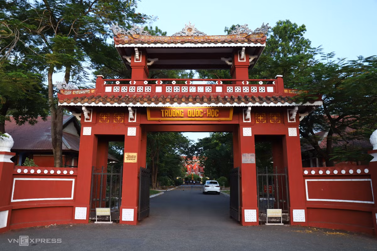 Cổng trường với lối kiến trúc cổ kính có hai tầng, tầng trên bằng gỗ, mái lợp ngói hoàng lưu ly. Muốn đi lên tầng trên phải qua cái thang hình xoắn ốc, trên có treo một cái chuông lớn để điểm giờ học. Phía tay phải có bình phong long mã, được xây dựng vào năm Thành Thái thứ tám, dấu tích ấy còn được lưu giữ đến ngày nay.
