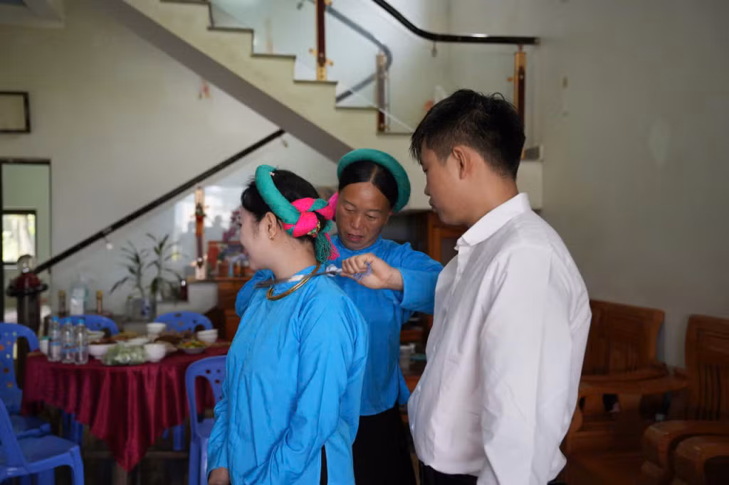Bà mối đang sửa lại vấn tóc và khăn cho cô dâu.