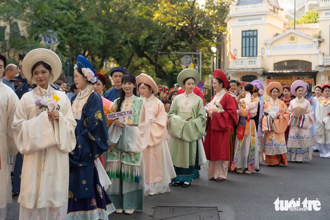 Sự xuất hiện của đoàn diễu hành khiến cả tuyến phố thêm náo nhiệt, đông vui - Ảnh: NGUYỄN HIỀN