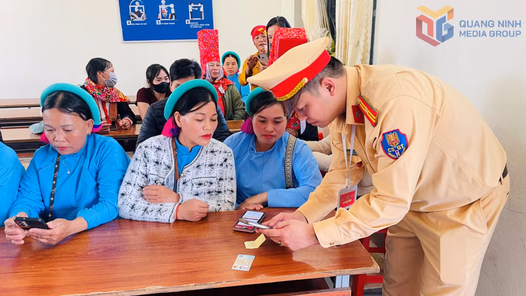 Cán bộ CSGT hướng dẫn thí sinh thi đạt tích hợp GPLX trên VNeID và cài đặt c ứng dụng VneTraffic để gửi phản ánh vi phạm giao thông.