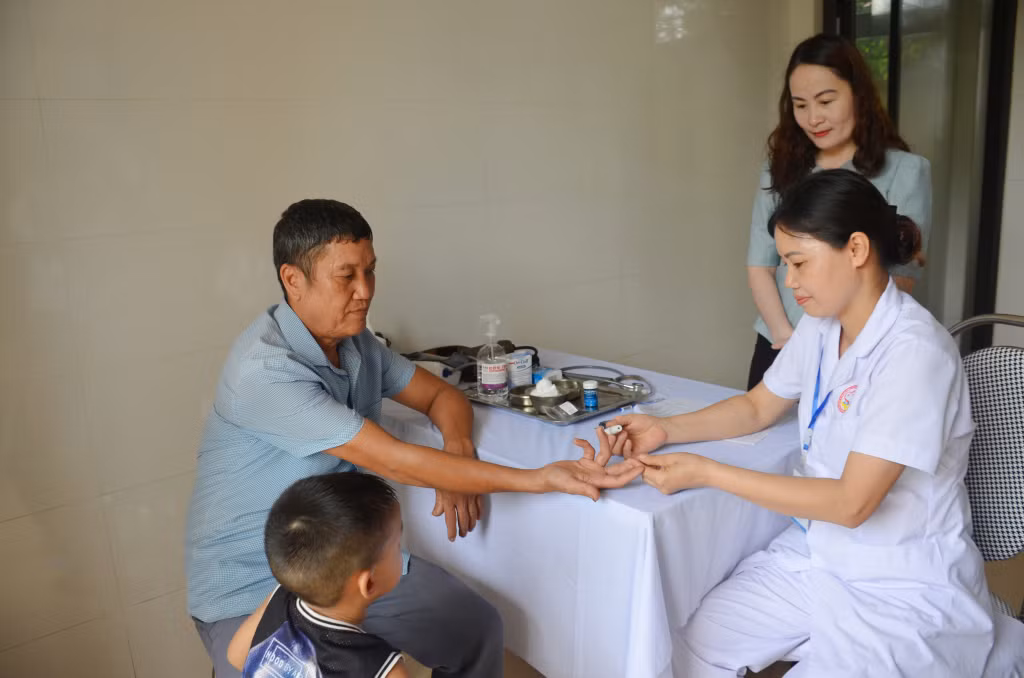 Bác sĩ Trạm y tế phường Phong Cốc (TX Quảng Yên) thử đường huyết sàng lọc bệnh tiểu đường cho người dân đến khám tại trạm.
