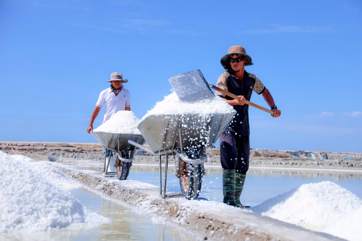 Muối kết tinh thành lớp dày trên mặt bạt, công nhân và diêm dân hàng ngày dùng xẻng đẩy, gọi là găng muối. Ảnh: Lữ Duy Tường